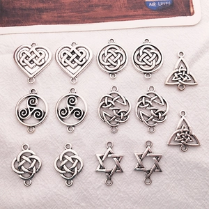 Detailed macro view of silver Celtic knot and hexagram metal charms for DIY jewelry