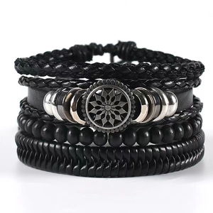 Détail d'un ensemble de bracelets multicouches en cuir pour homme avec perles et breloque