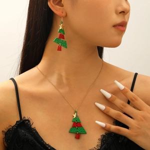 Detail view of a long Christmas tree necklace and earrings set with gold star accents