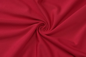 Gros plan détaillé sur la texture en tricot côtelé rouge foncé montrant l'élasticité