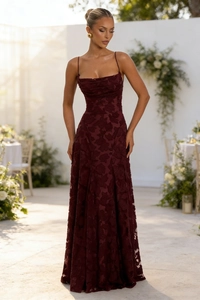 Detailed texture of burgundy lace gown fabric with slim straps and elegant draped collar