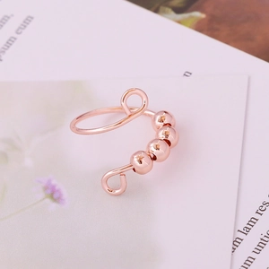Adjustable rose gold spinning bead ring for anxiety relief on card background