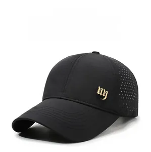 Detail of laser-cut ventilation holes and gold metal logo on a black quick-dry baseball cap
