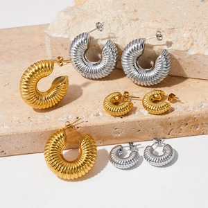 Twisted croissant hoop earrings in gold and silver finish with textured spiral design