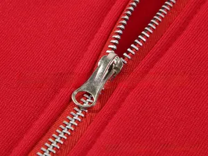 Close-up of silver metal zipper detail on bright red oversized drawstring hoodie