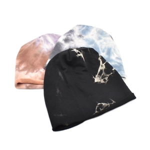 Three stylish tie-dye slouchy knit beanies in black, brown and blue displayed on white background
