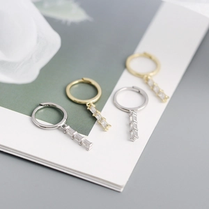 Close-up of geometric s925 silver hoop earrings with rectangular zircon pendants