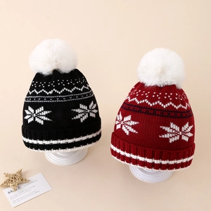 Set of two winter knit beanies with snowflake patterns and plush faux fur pom-poms