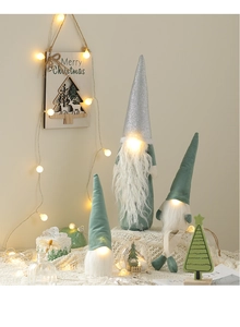 Close-up of three lighted Christmas gnomes with sequins and warm LED glow decor