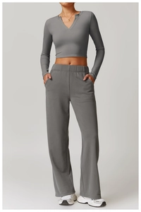 Detail view of dark grey yoga top and wide-leg joggers with functional side pockets