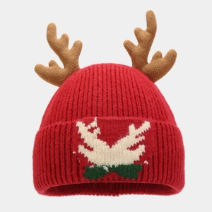 Close-up of red Christmas knit beanie featuring 3D antlers and jacquard reindeer patterns
