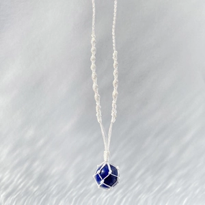 Collier fait main avec pendentif en lapis-lazuli bleu dans un filet de coton blanc