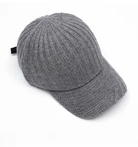 Close-up of gray knit baseball cap with vertical ribbed pattern and side woven label