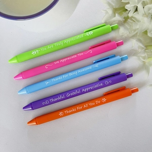 Close-up of five colorful retractable gel pens with inspirational quotes and floral patterns