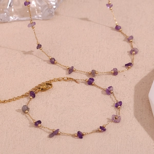 Detailed view of purple crystal stone necklace and bracelet set with gold chain lobster clasp