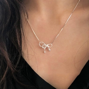 Elegant S925 silver bow pendant necklace on model with minimalist snake chain