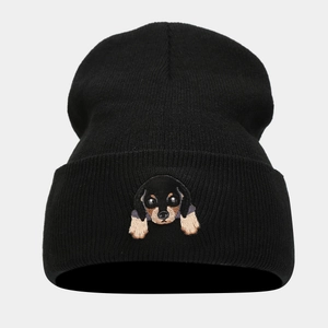 Close-up of the cute puppy embroidery on a thick black knitted beanie for winter