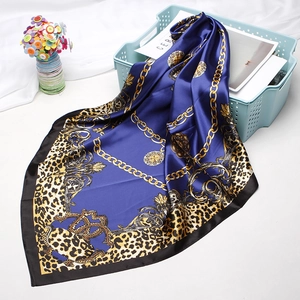 Detail of blue satin silk square scarf with golden leopard print and baroque chains