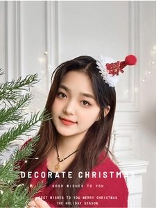 Détail d'une pince à cheveux de Noël avec mini chapeau rouge et nœud en décor festif