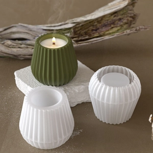 Vue macro du moule en silicone cylindrique avec une bougie verte finie sur socle