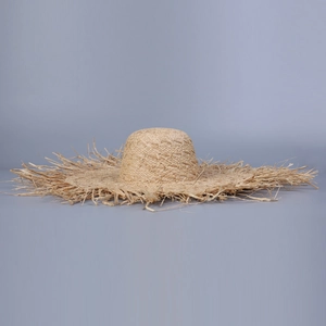 Détail d'un chapeau de soleil en raphia à large bord avec bords effilochés pour la plage