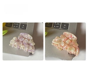 Detailed macro view of purple and pink acetate flower hair claws with crystal centers