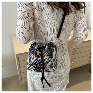 Detailed view of the ethnic nylon fabric texture and drawstring closure on the bucket bag