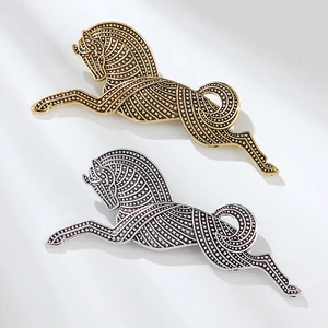 Detailed macro view of vintage gold and silver horse brooches with stippled metal texture