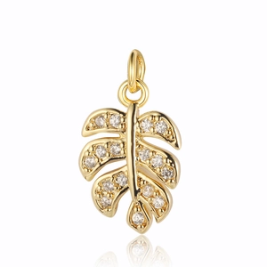Macro detail of gold monstera leaf pendant with sparkling zircon gemstones