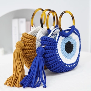 Three woven crochet handbags with tortoiseshell handles and decorative long tassels in blue and white