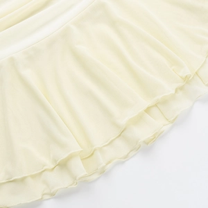 Macro detail of the creamy yellow knitted fabric with delicate ruffled edge design
