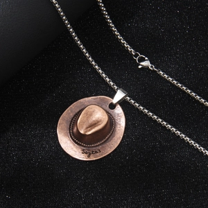 Vintage Edelstahl Cowboyhut Anhänger Halskette mit Metallkette auf schwarzem Stoffhintergrund