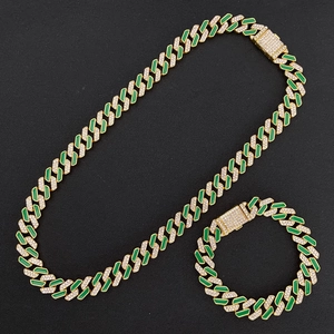 Close-up of gold Cuban link necklace set with green enamel and sparkling diamonds