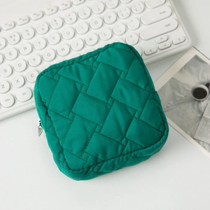 Détail de la trousse de maquillage verte matelassée avec texture tissée et zip argenté