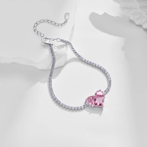 Detail of S925 sterling silver tennis bracelet with pink heart-shaped gemstone and lobster clasp