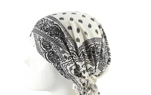 Detail view of pre-tied headwrap with black and white paisley floral pattern on a mannequin