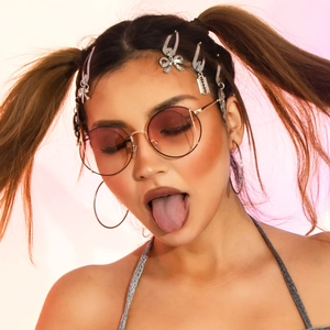 Detail of round metal sunglasses with gradient lenses and Y2K aesthetic hair accessories