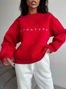 Women's red crewneck sweatshirt with white embroidery paired with casual pants