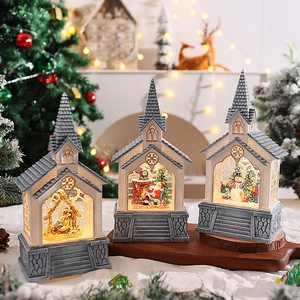 Three lit Christmas church snow globes with Nativity and Santa scenes on snowy wood tray