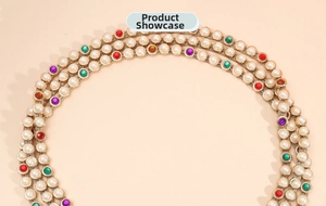 Detailed close-up of handmade gold chain belt with colorful gems and white pearls