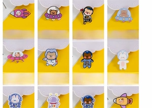 Detail view showing assorted space-themed acrylic brooches with rocket and astronaut motifs