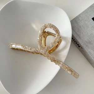 Macro shot of a 13cm marble texture hair claw clip with golden metal spring and cross design