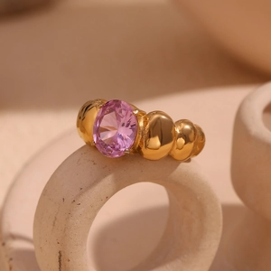 Detail of 18K gold plated beaded ring with a pink oval zircon on a ceramic holder