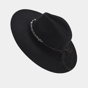 Close-up of black felt fedora hat featuring vintage turquoise beaded band and tassel detail
