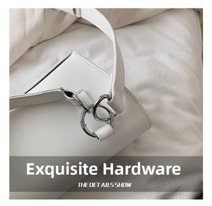 Close-up of premium silver double-ring hardware on a minimalist white leather crossbody bag