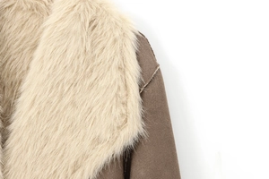 Detail of faux fox fur collar and brown faux suede stitching on double-sided long coat