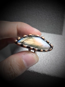 Macro shot of oval labradorite ring with colorful flash and antique bronze setting