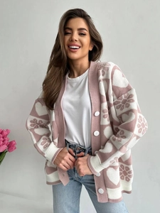 Détail d'un gilet jacquard à cœurs rose et blanc avec texture en maille douce et boutons