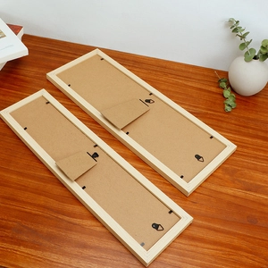 Rear view of wooden picture frame showing sturdy support stand and metal hanging clips