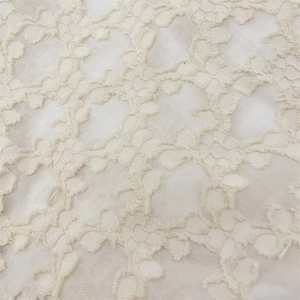 Macro shot of the off-white jacquard lace fabric with intricate floral texture and details
